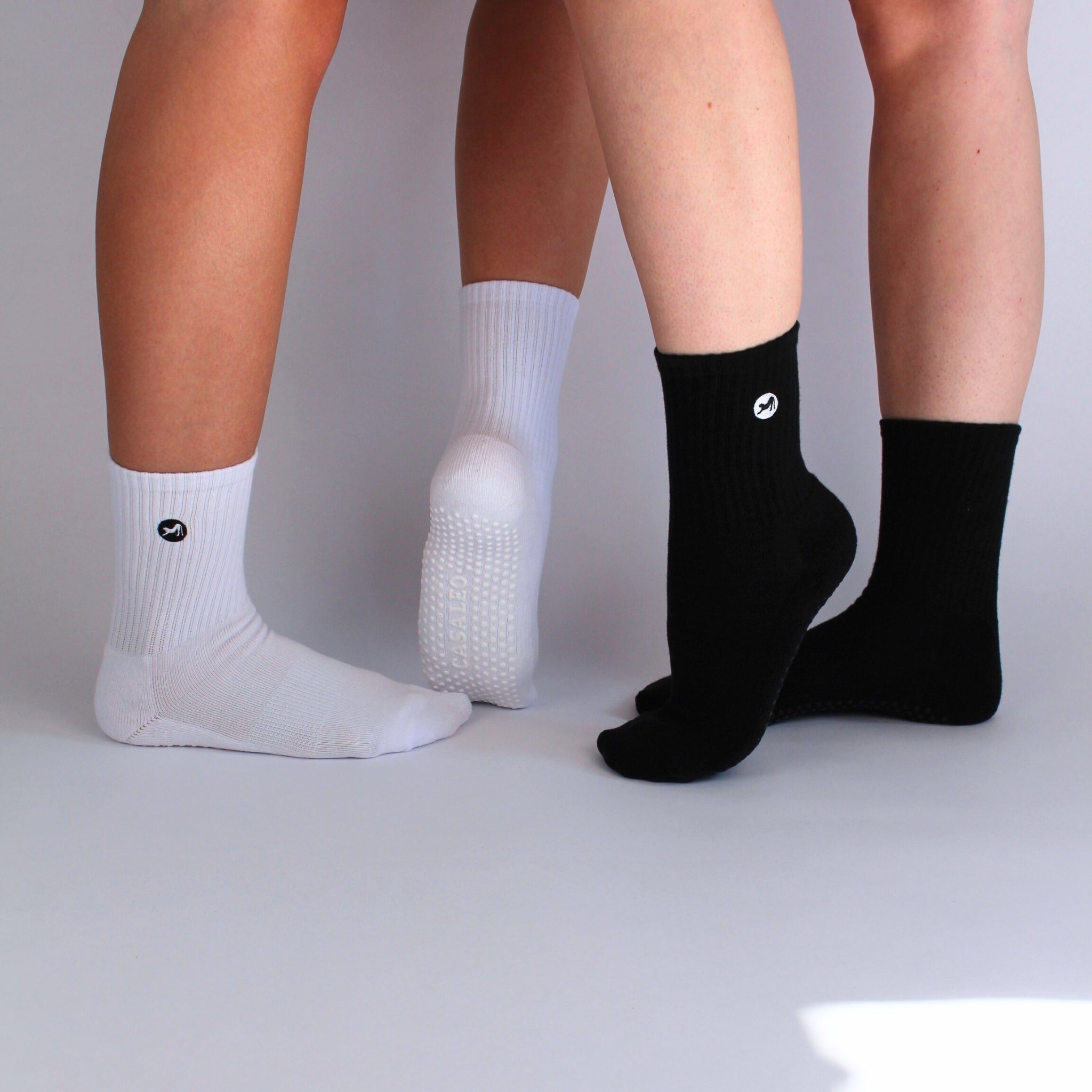 CASALEO Grip Socken in Schwarz und in Weiß vor einer Foto Leinwand