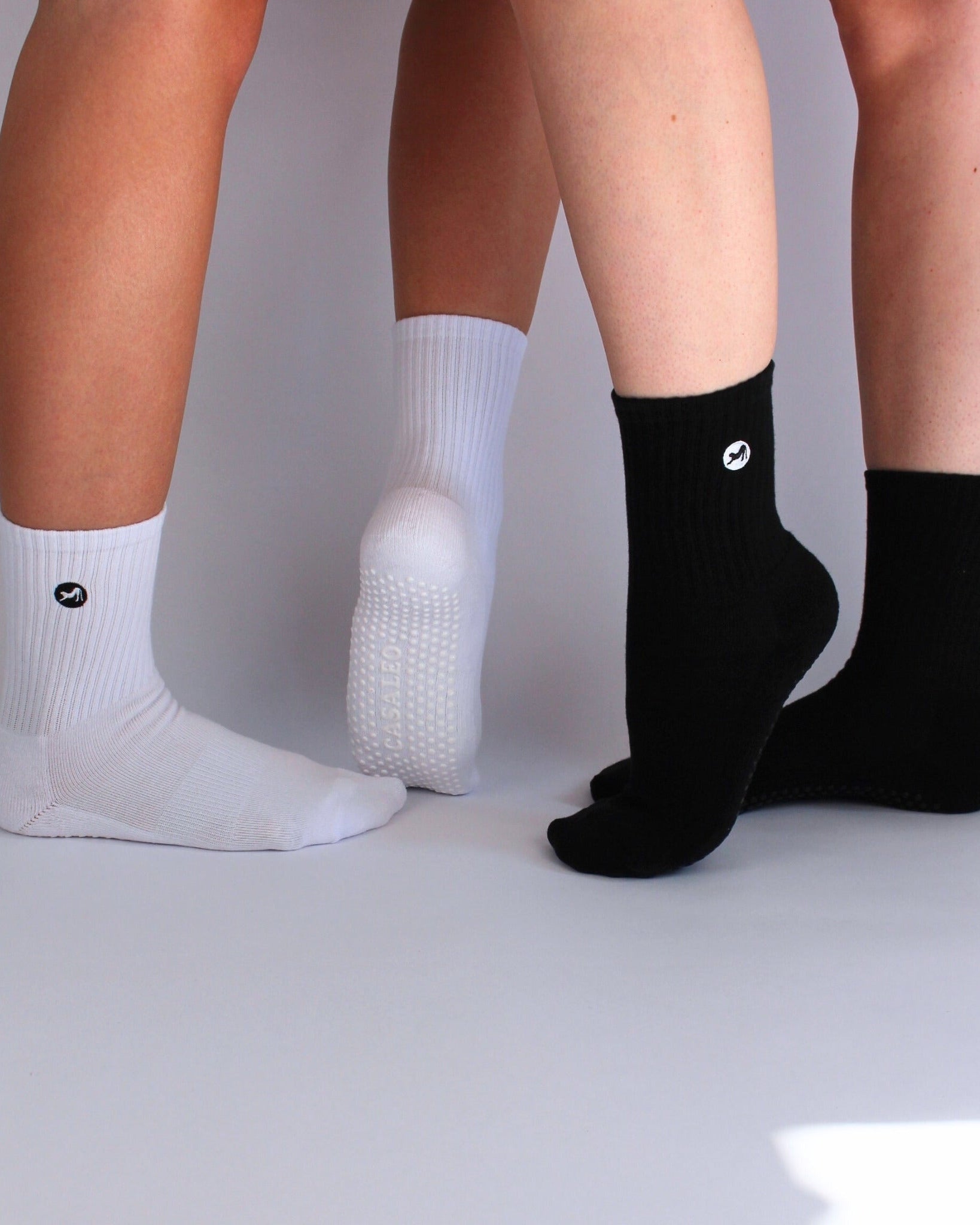 CASALEO Grip Socken in Schwarz und in Weiß vor einer Foto Leinwand