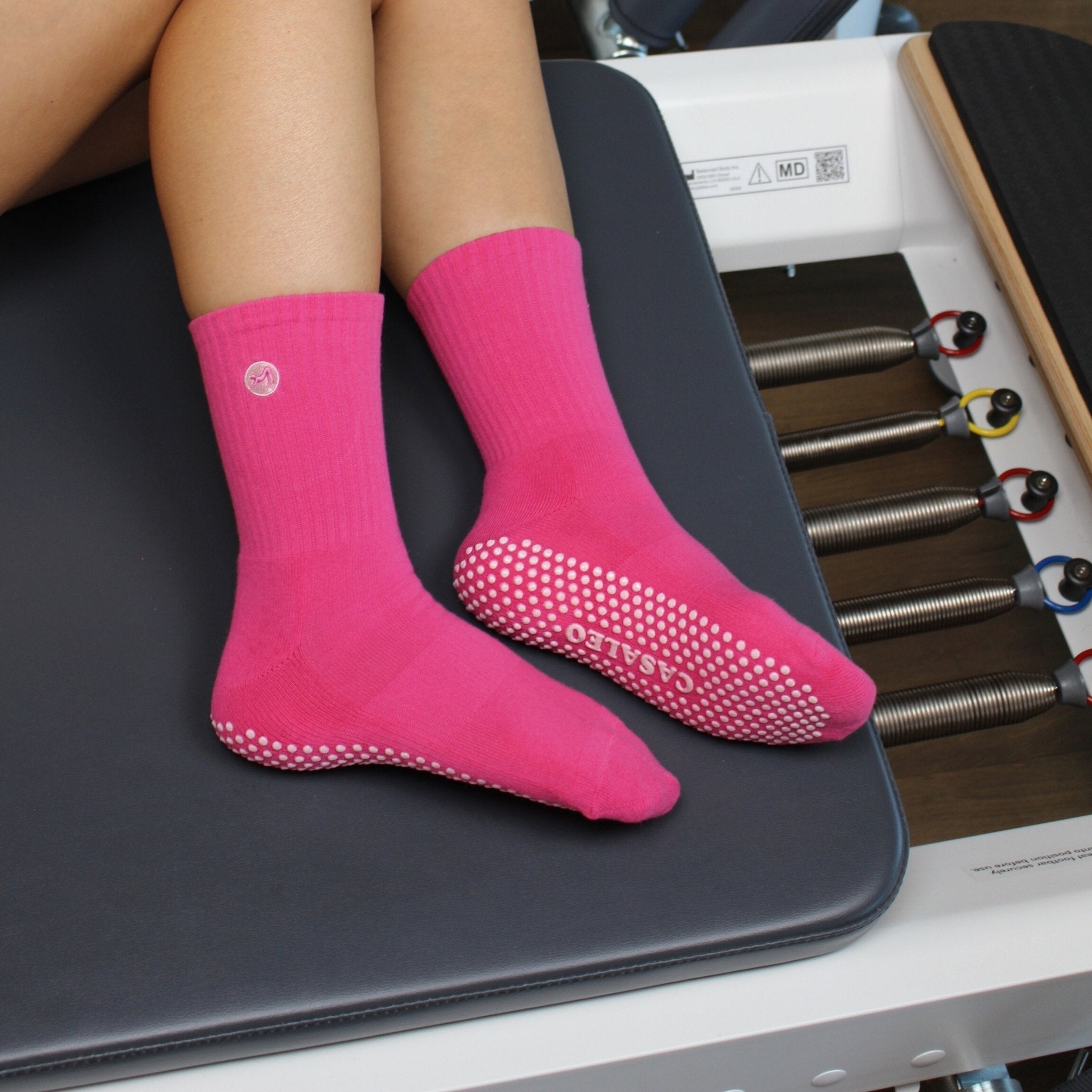 CASALEO Grip Socken in Magenta von der Seite auf dem Reformer Gerät