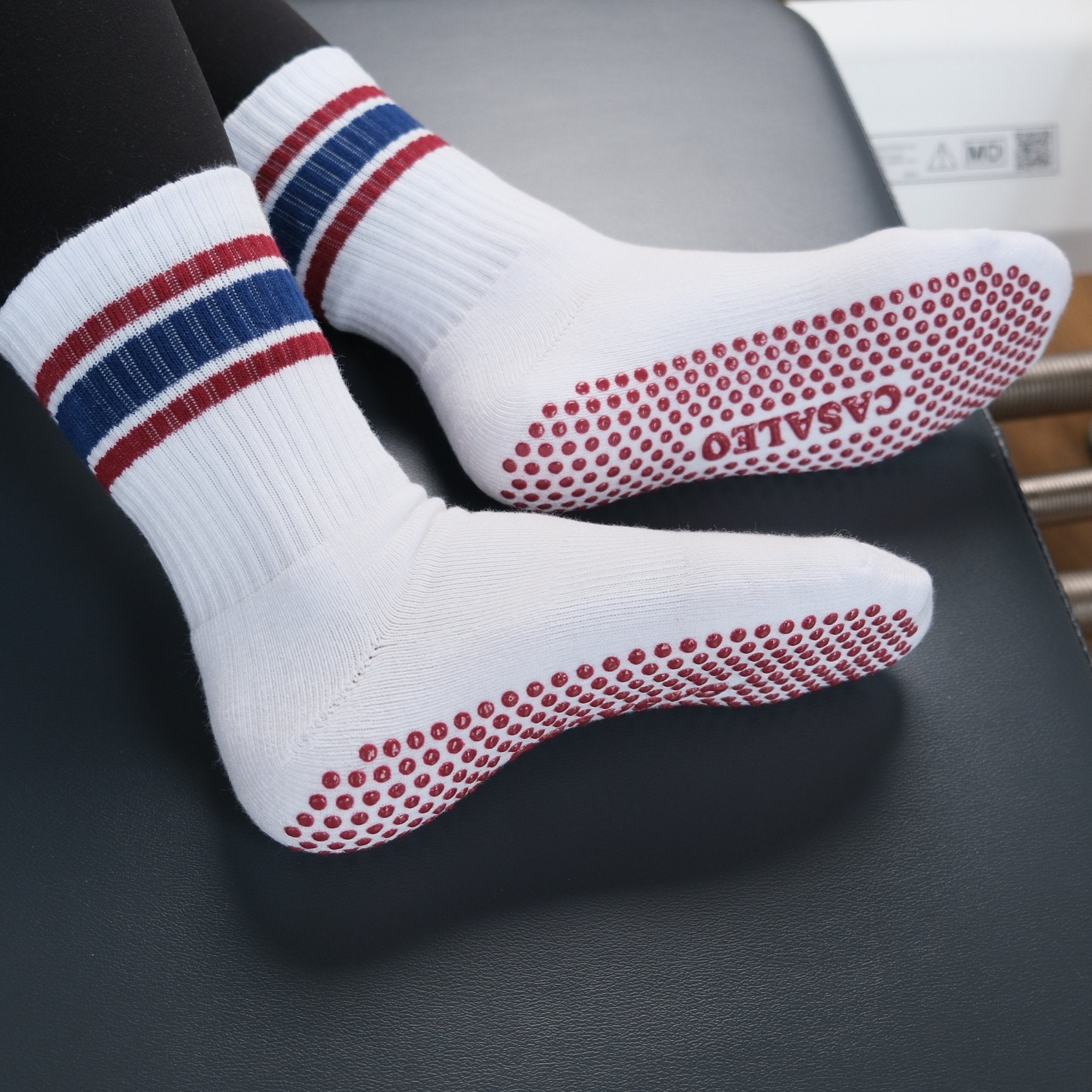 Weiße CASALEO Grip Socken mit Streifen auf dem Reformer von unten