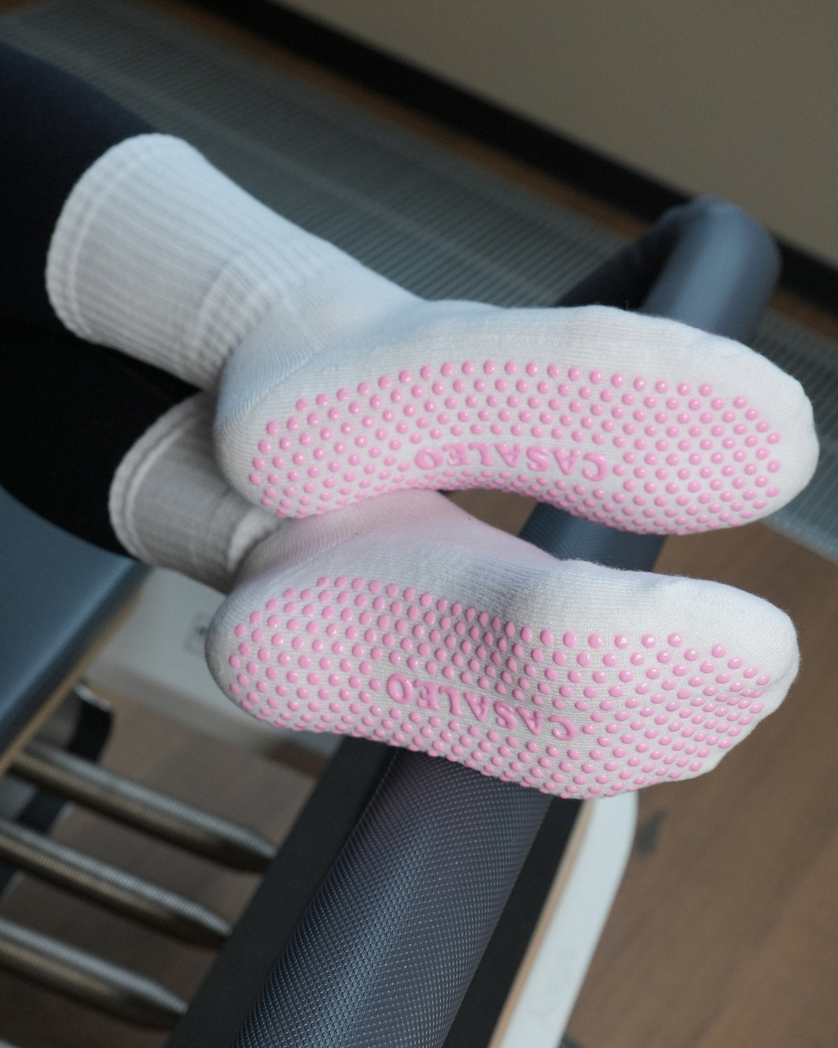 casaleo Pilates Socken in Weiß mit Pink Akzenten von oben auf dem Reformer