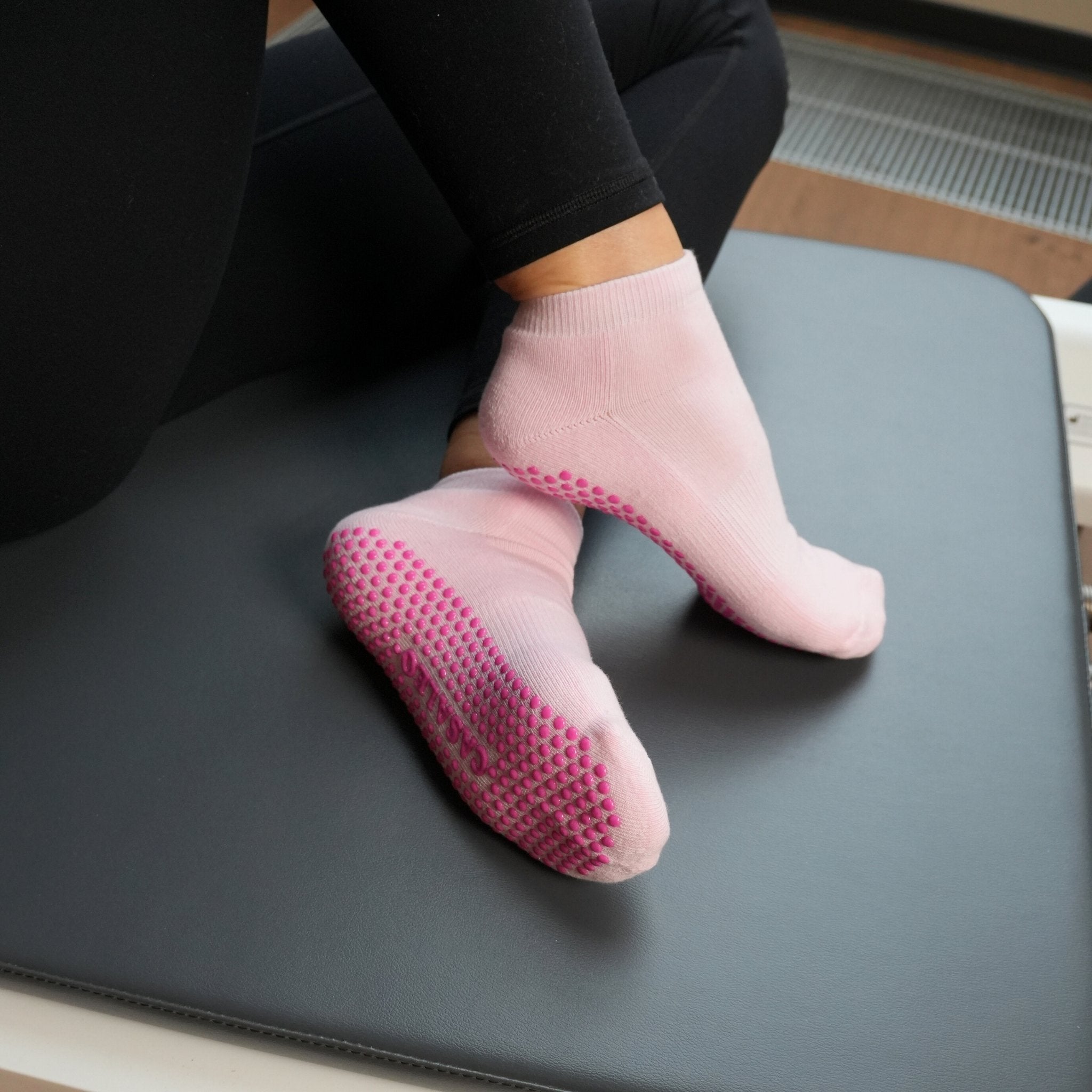 CASALEO Pilates Socken in Pink und kürzerer Länge auf dem Reformer