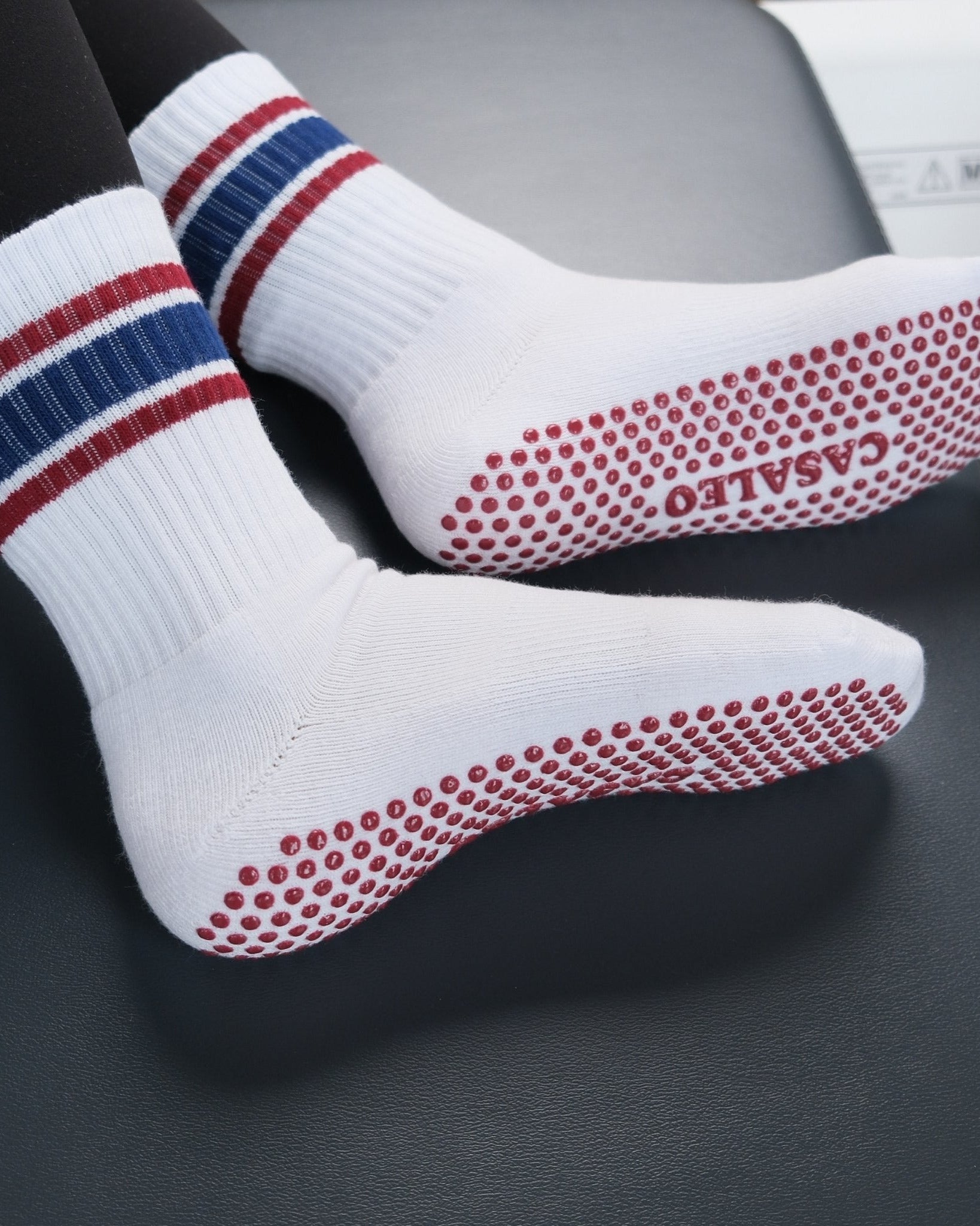 Weiße CASALEO Grip Socken mit Streifen auf dem Reformer von unten