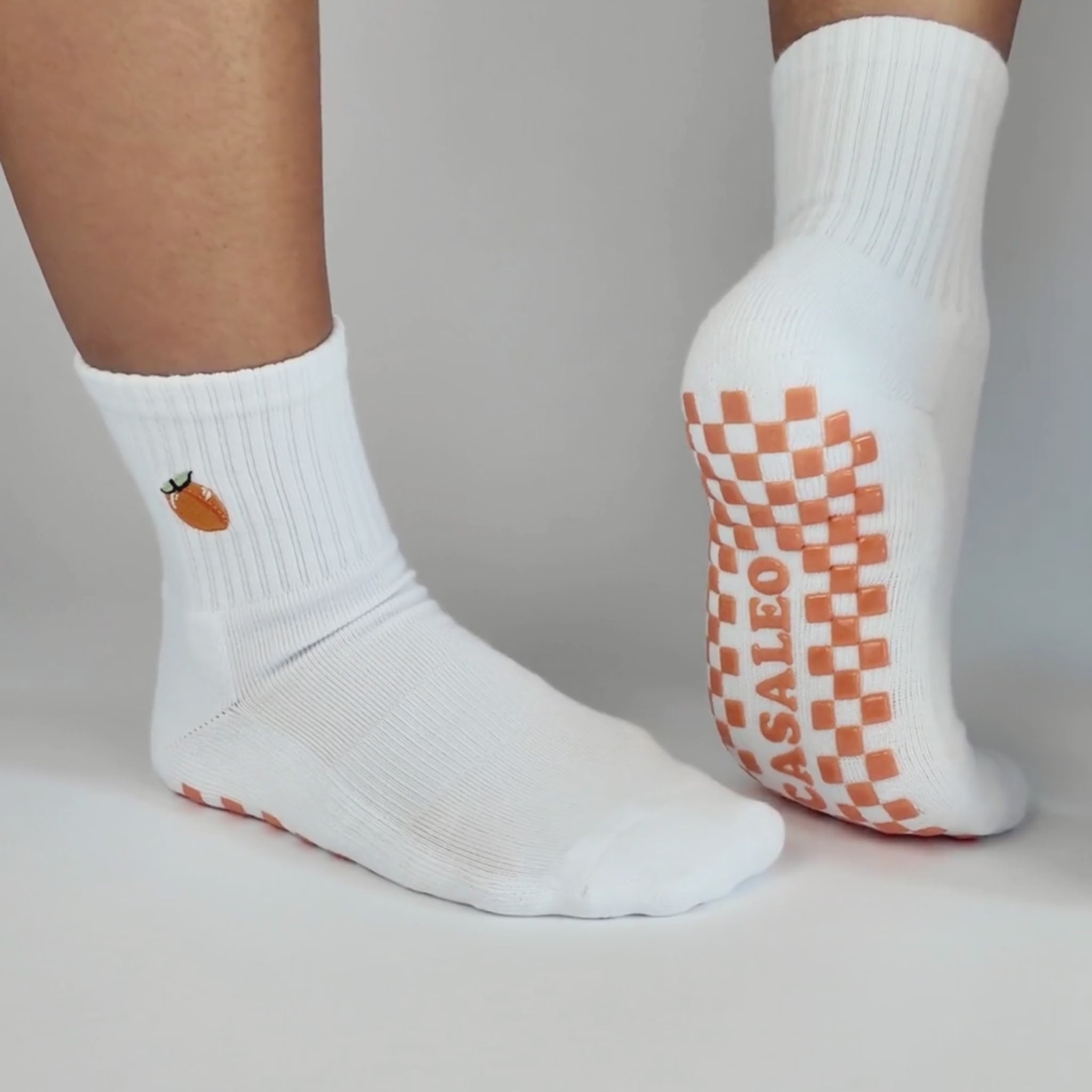CASALEO Grip Socken mit roter, orangener und gelber Grip Sohle vor einer Fotoleinwand